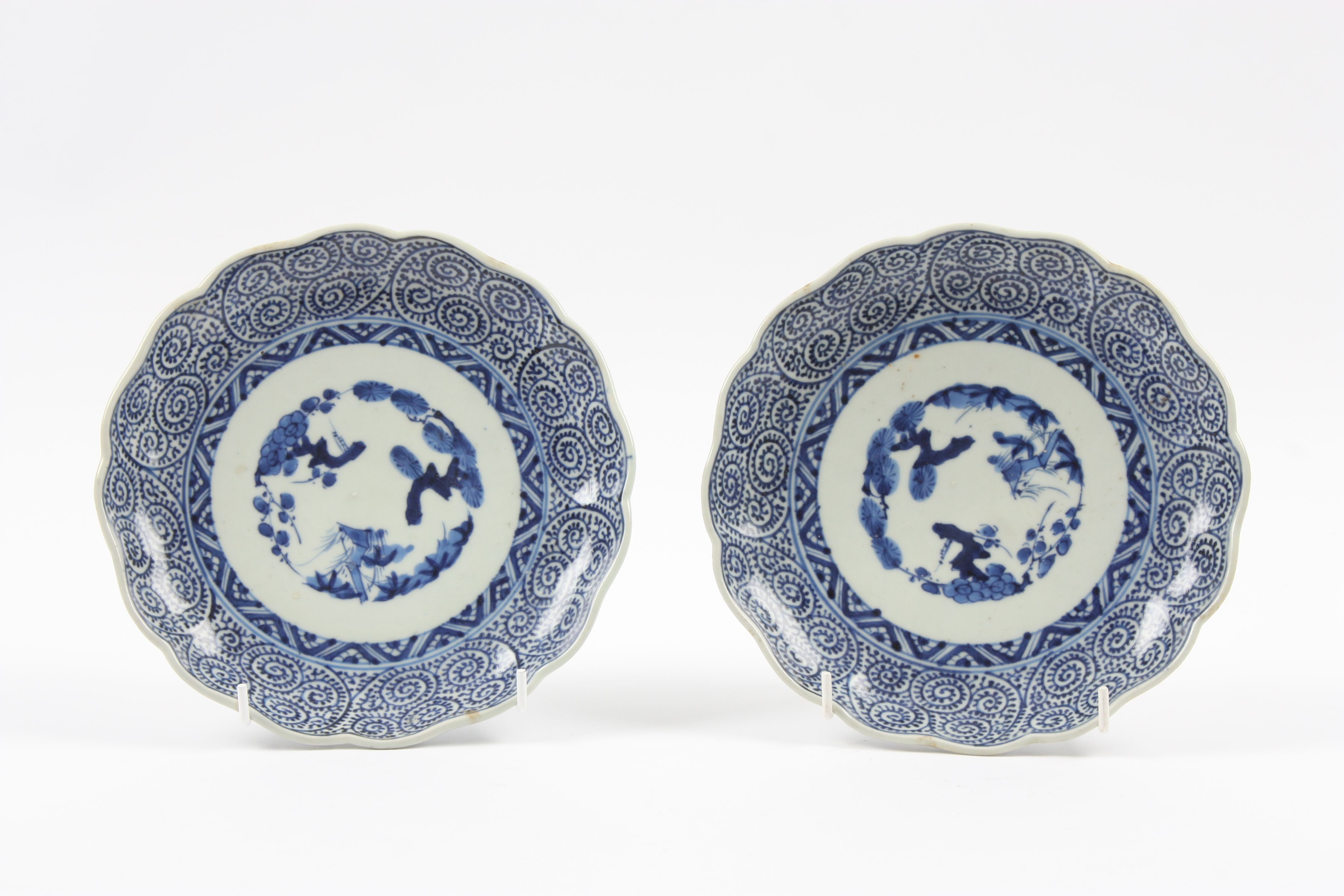 A pair of Chinese late Qing dynasty circular plates with shaped rims, painted with naive landscape
