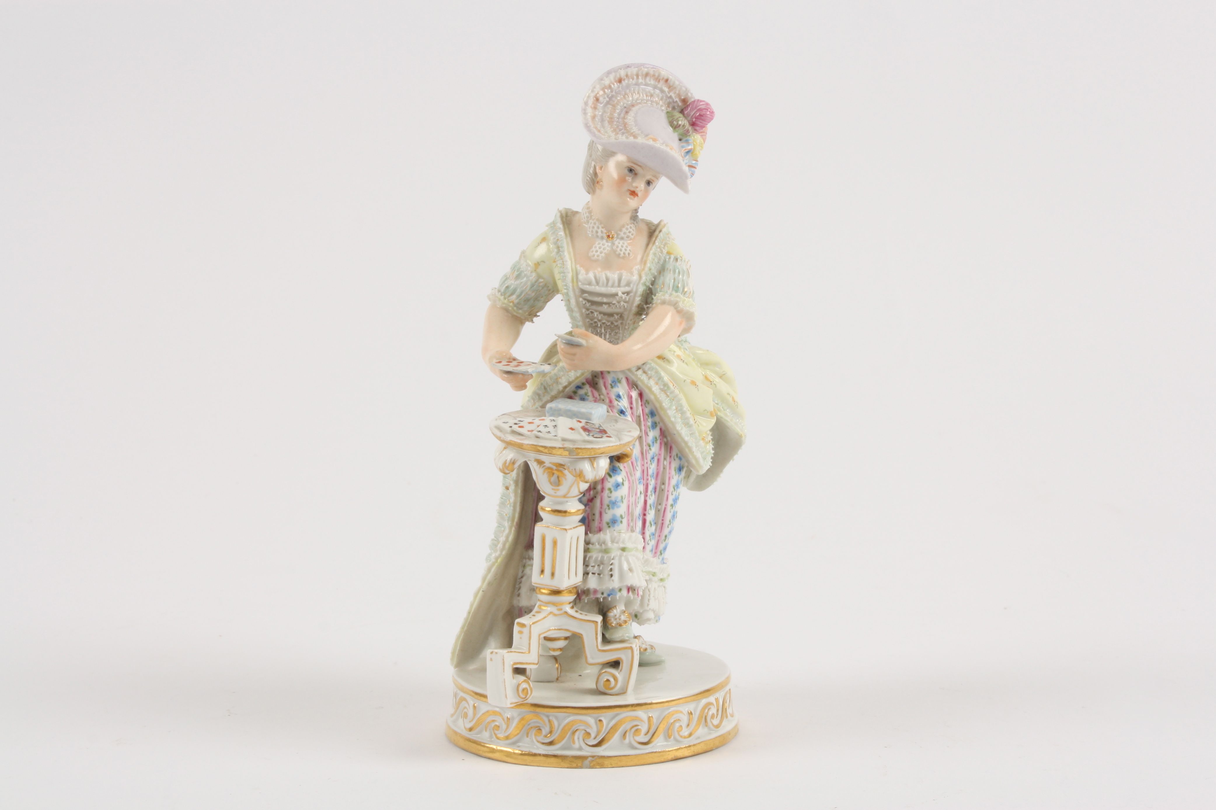 A 19th century Meissen porcelain figure of a young lady playing cards in standing pose, dealing