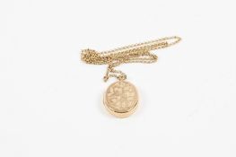 A 9ct gold oval locket and chain stamped .375, the locket engraved with scrolling flowers. 24.8