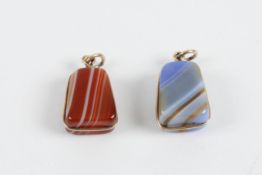 Two gold mounted banded agate pendants each of rectangular tapering form with twisted unmarked