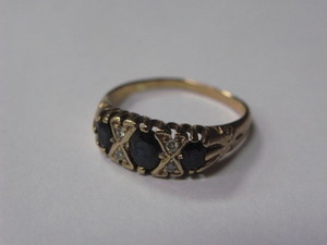 9ct GOLD DRESS RING SET WITH THREE DARK SAPPHIRES AND FOUR SMALL CLEAR STONES