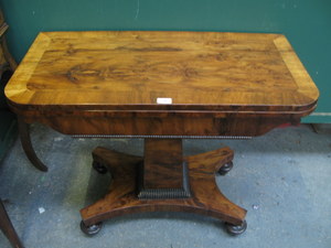 WALNUT VENEERED VICTORIAN FOLD OVER GAMES TABLE ON QUADRAFOIL SUPPORT