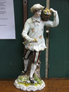 CONTINENTAL STYLE HANDPAINTED CERAMIC FIGURE OF A FRUIT PICKER, APPROXIMATELY 29.5cm HIGH