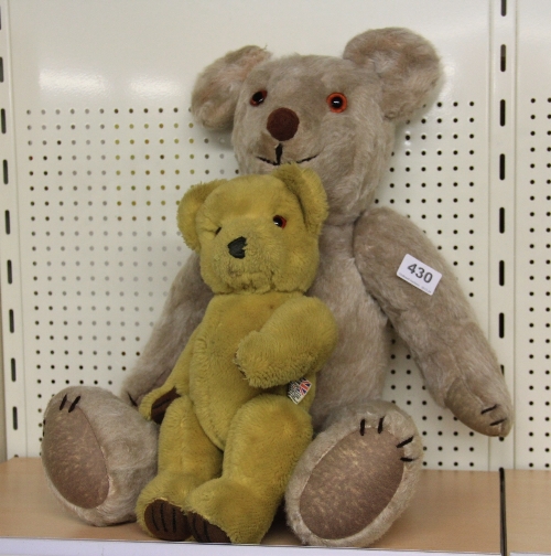 A large articulated straw filled teddy bear and one other