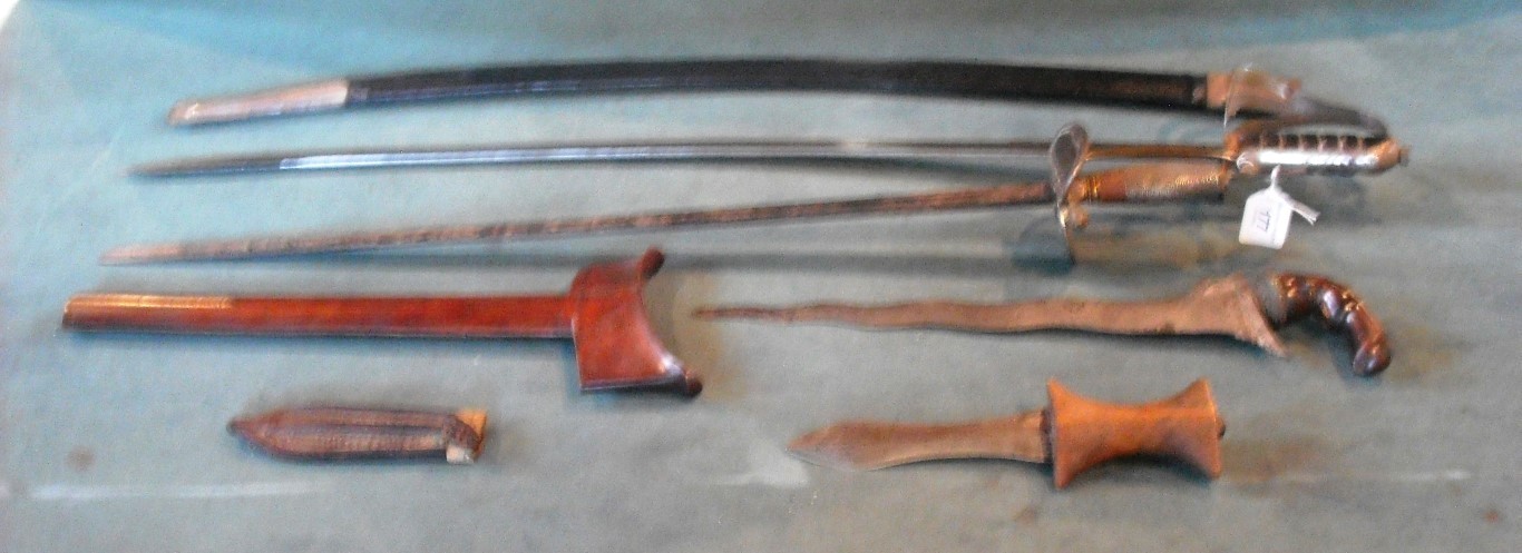 A mixed lot of edged weapons, including an Indian sword stick, kris, a small dagger with wood handle