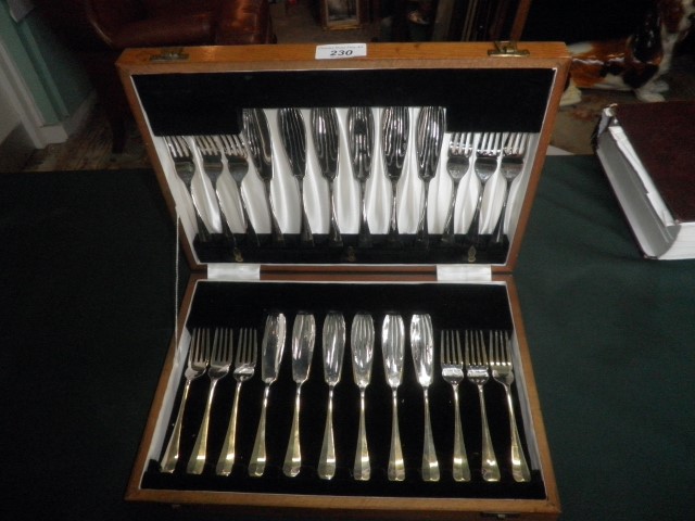 An oak cased canteen, containing a twelve place setting of silver plated fish knives and forks.