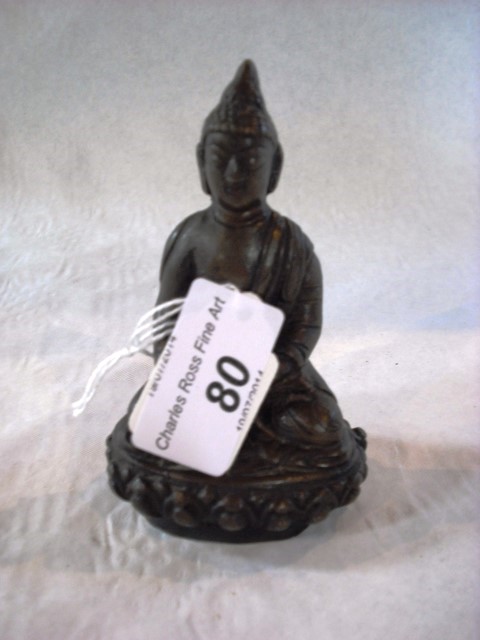 An 18th century cast bronze Buddha, seated cross legged with lowered right hand, 10cm.