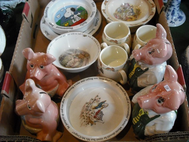 Four Wade Nat West pottery piggy banks, a Royal Doulton Bunnykins baby's plate, a conforming bowl,