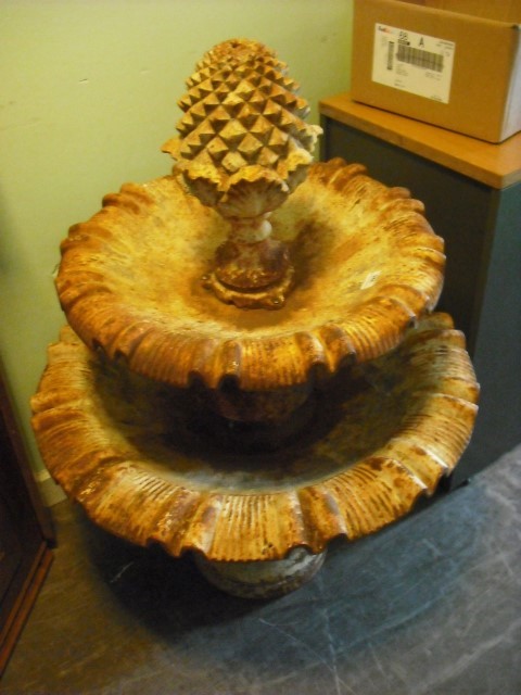 A cast iron fountain, the pineapple finial over a pair of graduated dished tiers on baluster