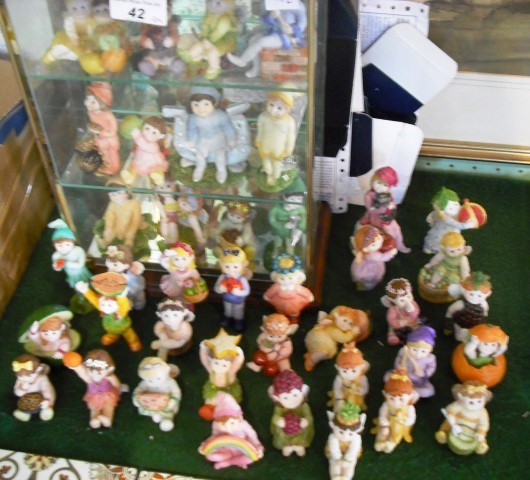 A large quantity of Fruit Fairy figurines, together with some original boxes and a display cabinet.