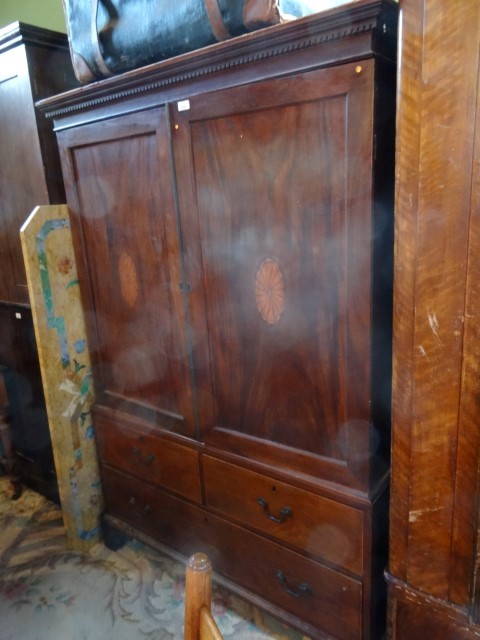 A George III mahogany linen press, having a moulded and dentil cornice, over a pair of fan inlaid