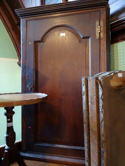 An early 19th century oak wall mounting corner cupboard, having moulded cornice over panelled