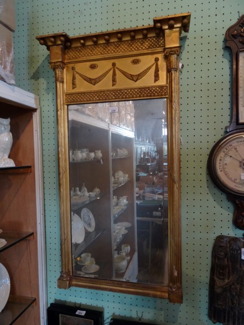 A Regency giltwood and gesso pier mirror, having inverted breakfront pediment with applied ball