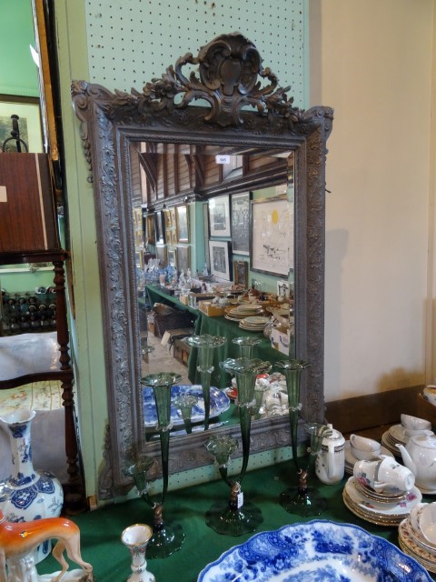 A 19th century later painted gilt wood and gesso wall mirror, having trailing flower and open