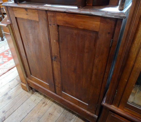 A 19th century pine cupboard, the rectangular top with moulded edge over a pair of panelled doors on