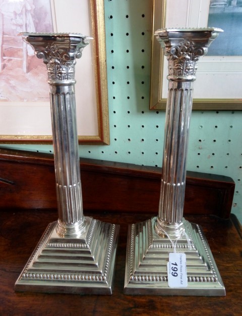 T & S, a pair of silver table candlesticks of Corinthian column form, each on a stepped square