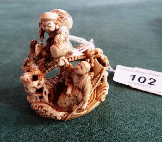A 19th century Japanese ivory netsuke, elaborately carved with a figure riding a mouse across a