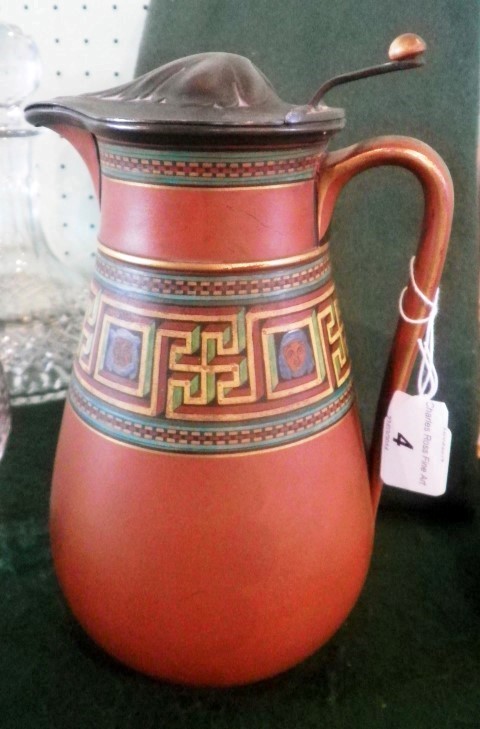 A late 19th century terracotta jug of baluster loop handled form, having a pewter cover and