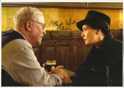 Michael Caine signed 12 x 8 colour photo in later years sitting at table talking to a very pretty