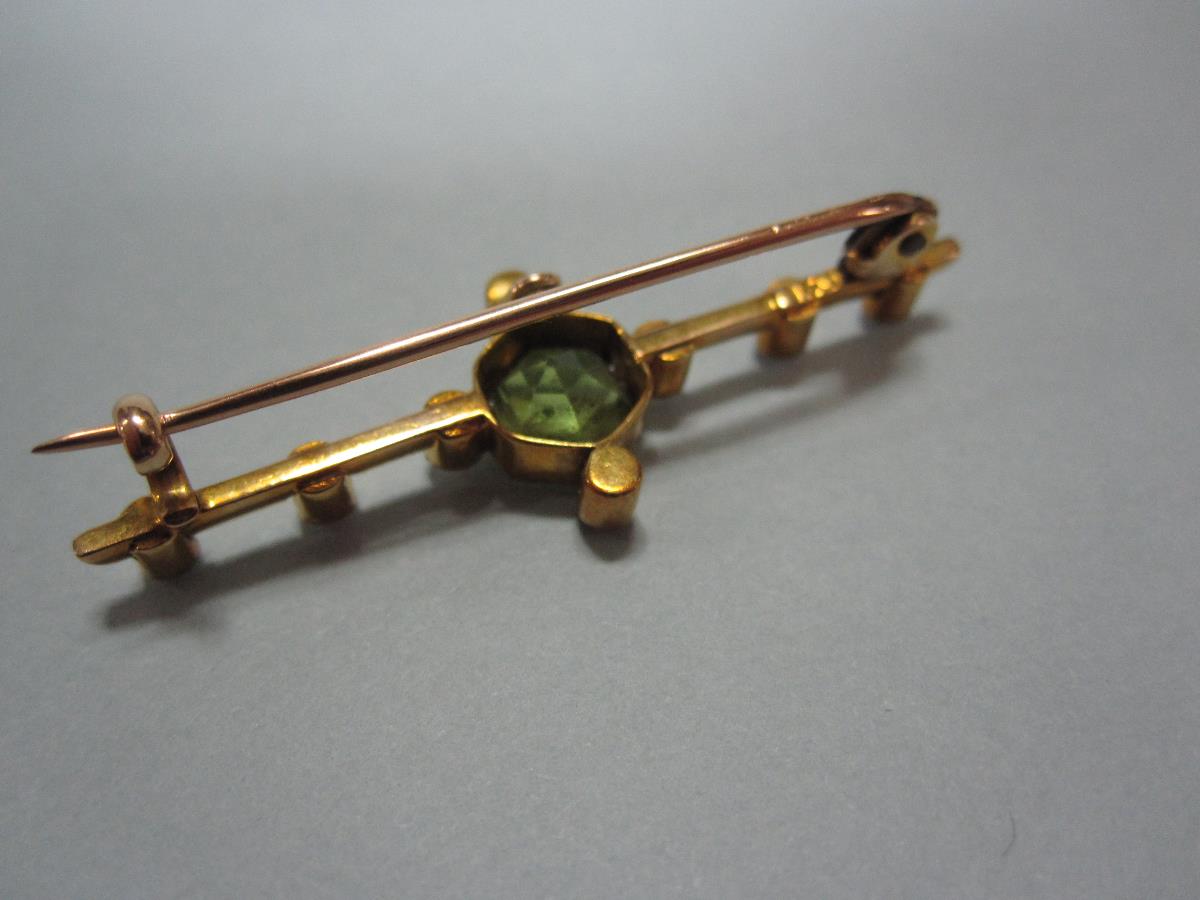 A peridot, seed pearl and ruby bar brooch in fitted case, the central hexagonal cut peridot in - Bild 3 aus 3