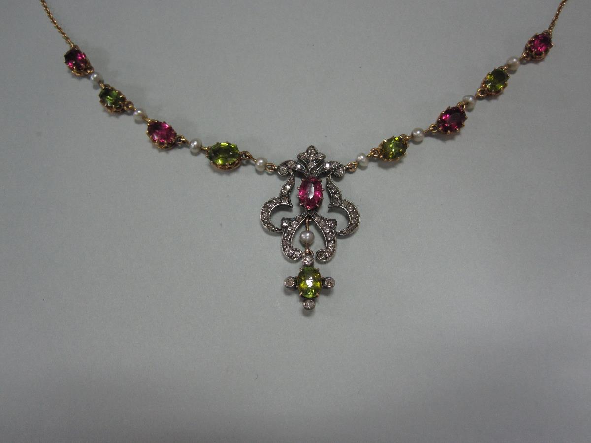 A late Victorian diamond, peridot and pink tourmaline necklace, the central focus an open scrolling