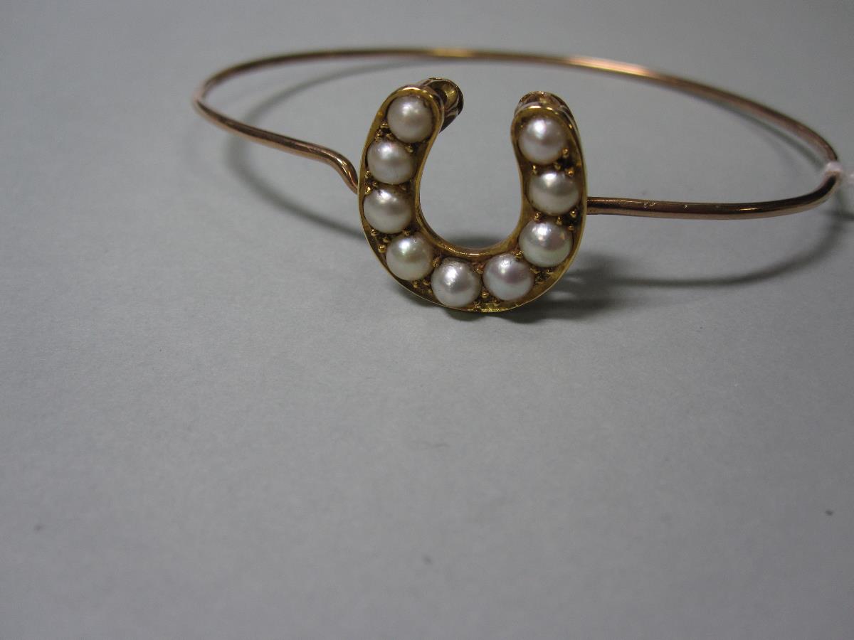 A pearl set horseshoe on a wire bangle, the horseshoe of unmarked yellow precious metal set with a - Bild 4 aus 4