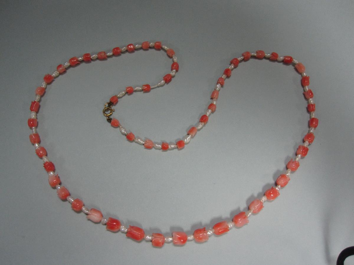 A carved coral and pearl necklace, the graduated string of coral beads carved as bell flowers or