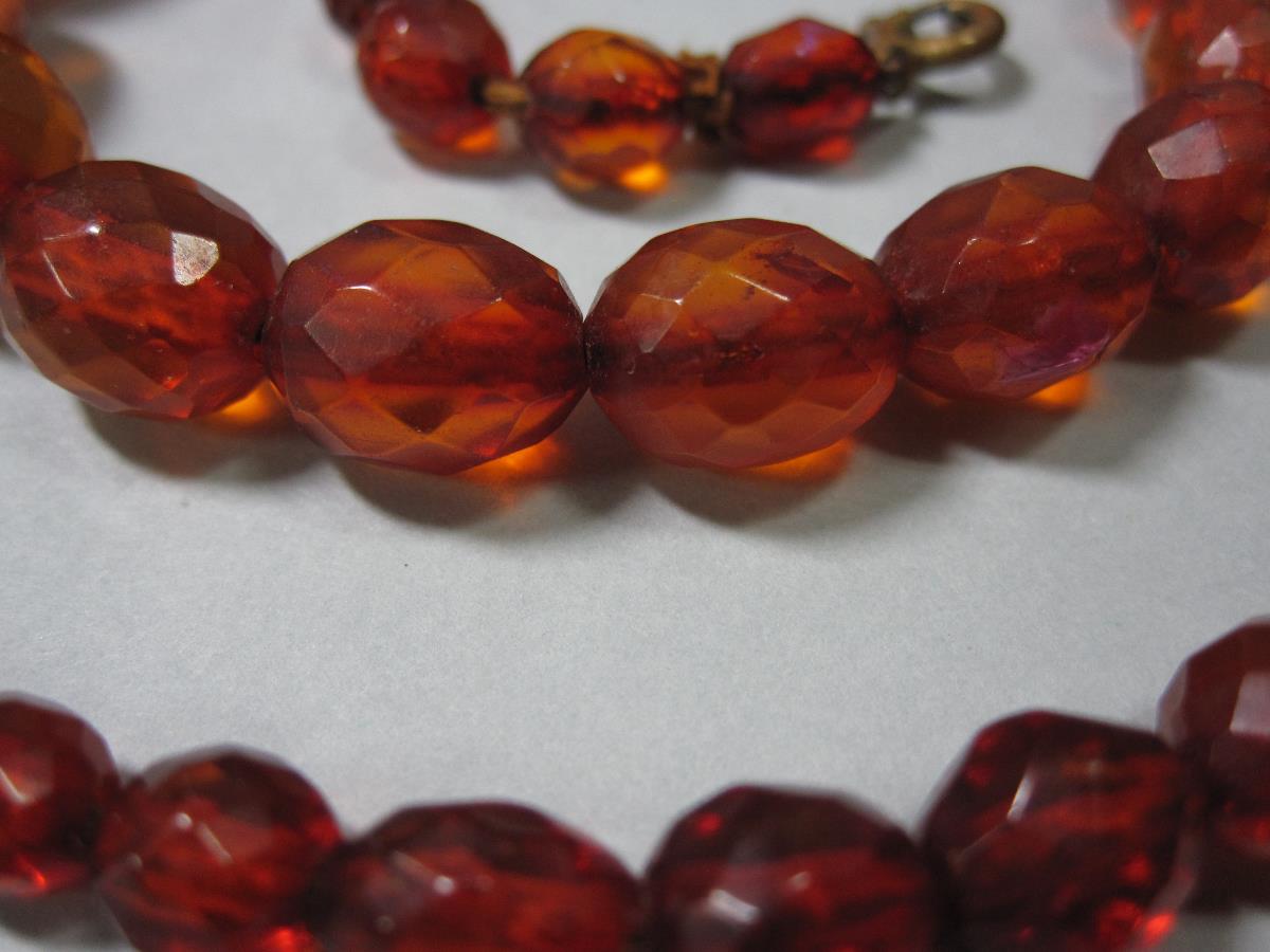 A vintage faceted amber bead necklace, the forty-one graduated oval harlequin faceted beads of - Bild 4 aus 5