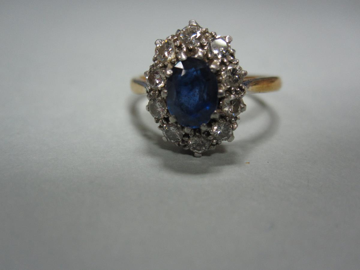 A sapphire and diamond cluster ring, the oval cut sapphire claw set in a border of ten round - Bild 4 aus 4