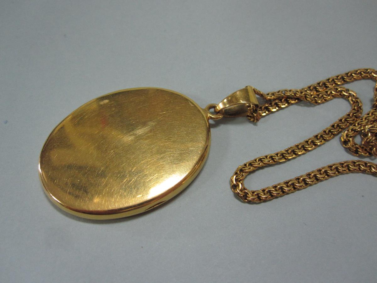 A 19ct gold locket and chain, the oval locket with bright cut decoration on one side and on the - Bild 2 aus 3