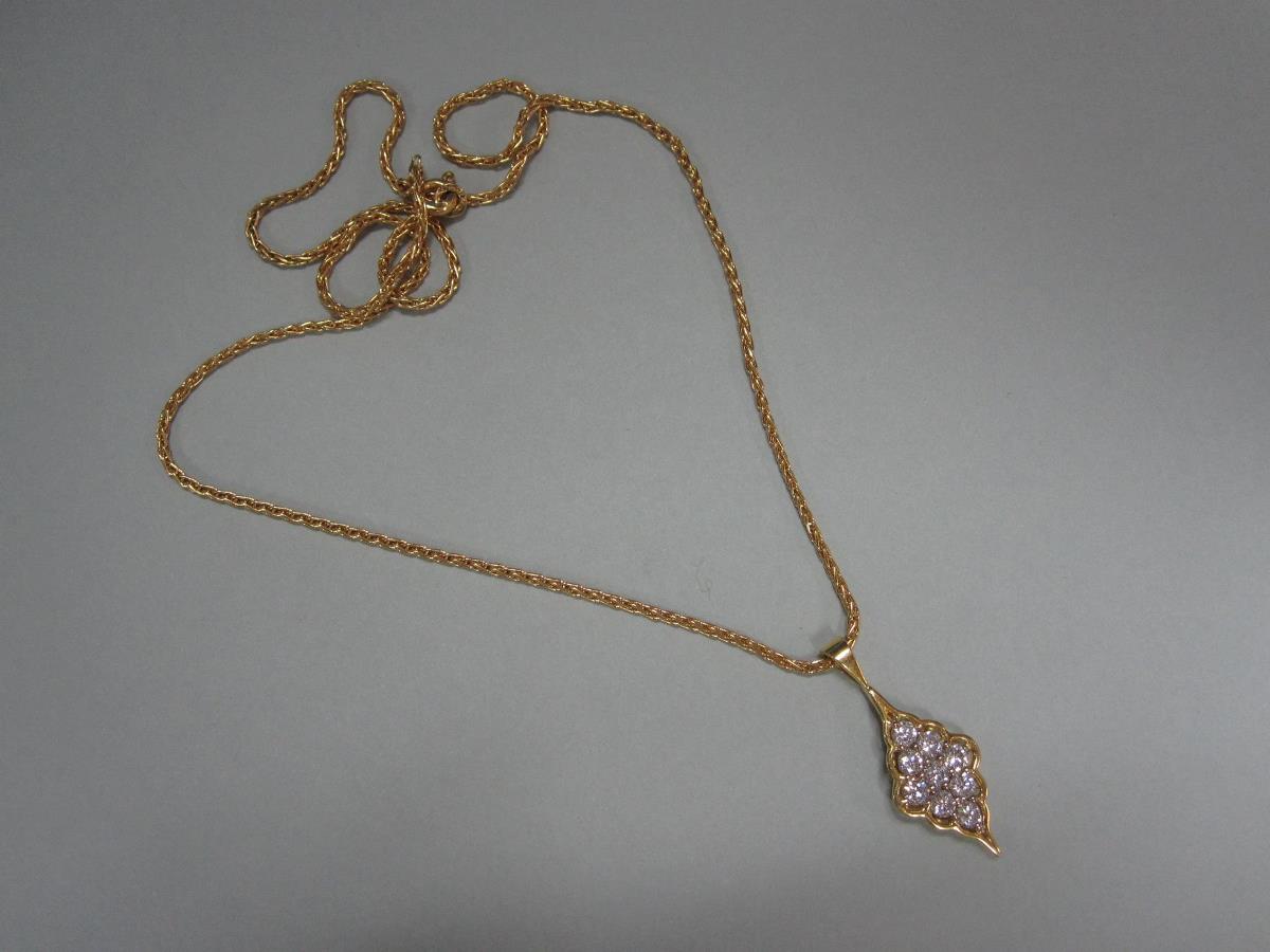 A modern diamond and 18ct gold pendant and chain, the pendant of scallop-edged diaper form set