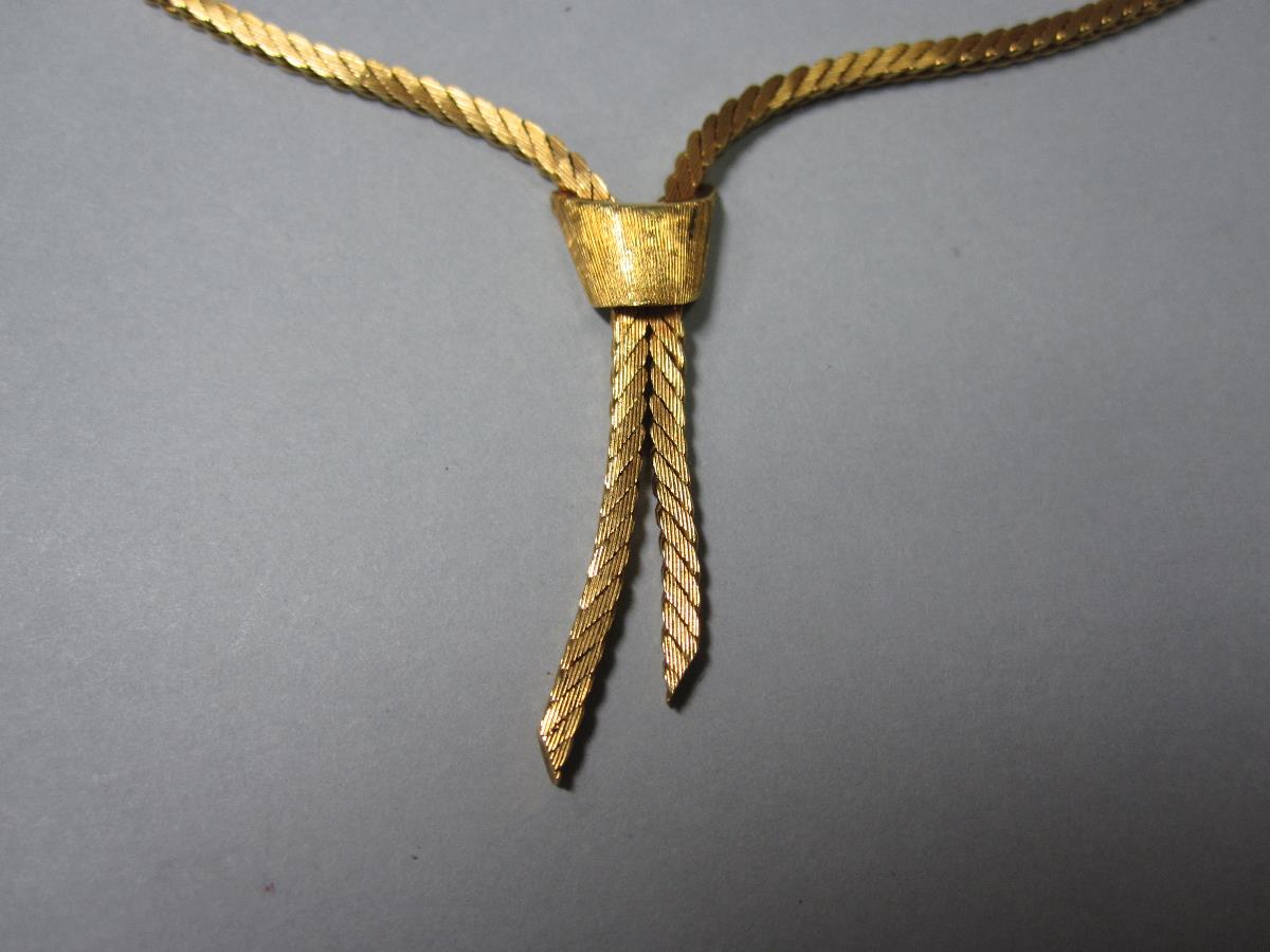 An 18ct gold modern negligée necklace, formed of flattened textured snake links with ribbon end