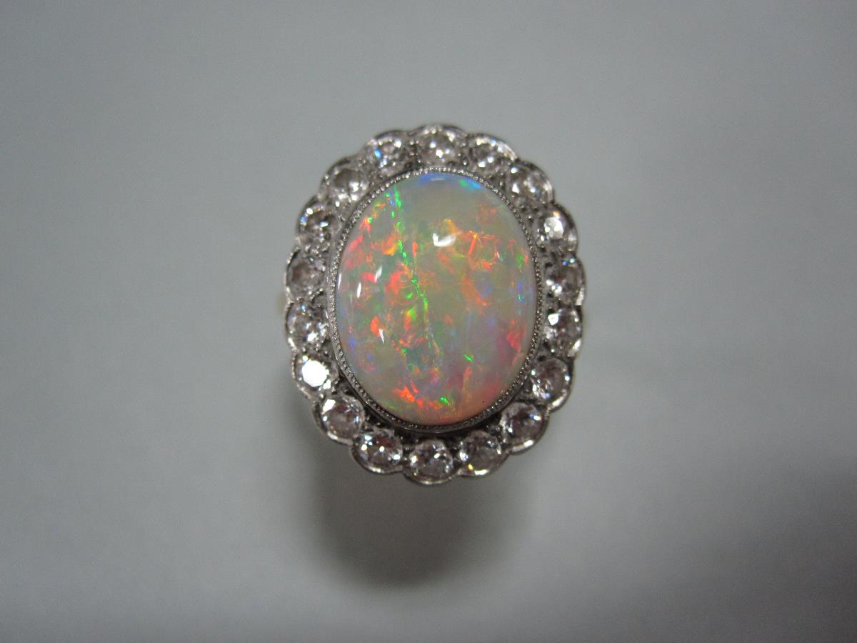 An opal and diamond cluster ring, the oval cabochon opal, exhibiting a fine and rainbow ranged play - Bild 4 aus 4