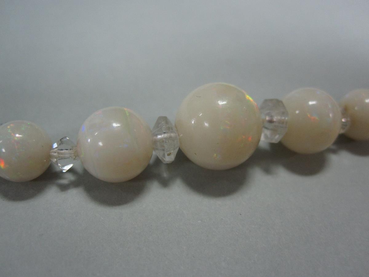 A graduated opal bead necklace, the 4-11mm round milky opal beads spaced principally by angled