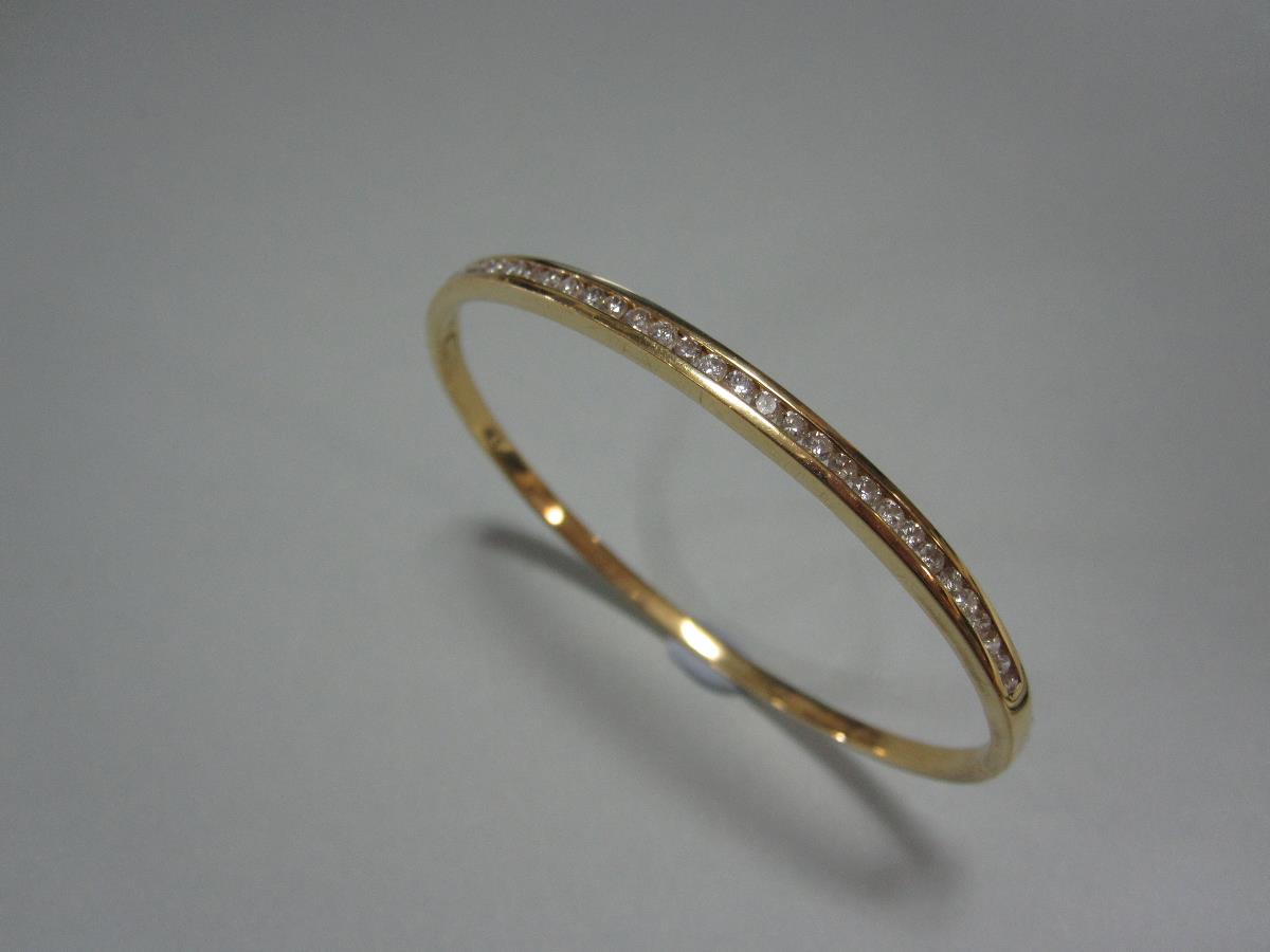 An 18ct gold and diamond hinged bangle, the plain narrow rectangular section bangle channel set to - Image 4 of 4