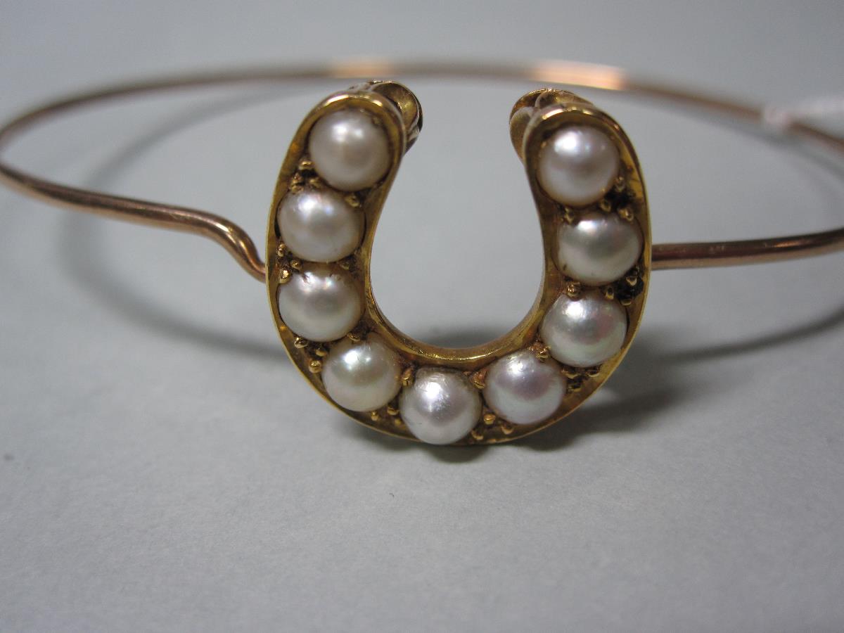 A pearl set horseshoe on a wire bangle, the horseshoe of unmarked yellow precious metal set with a - Bild 3 aus 4