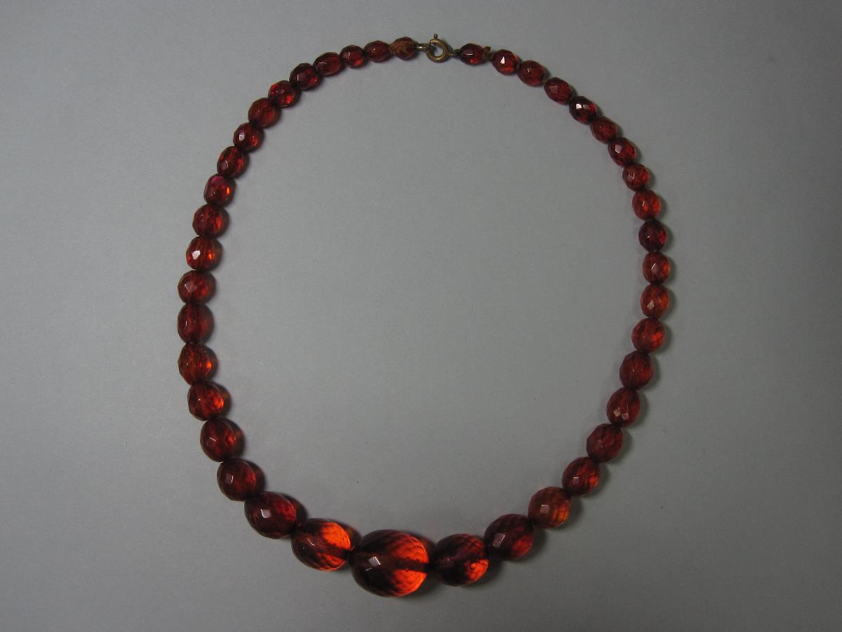 A vintage faceted amber bead necklace, the forty-one graduated oval harlequin faceted beads of