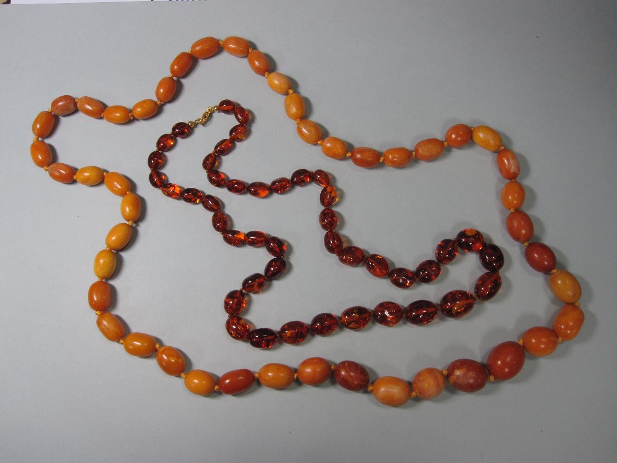 A vintage butterscotch amber bead necklace and another, the first of graduated 15-23mm long oval