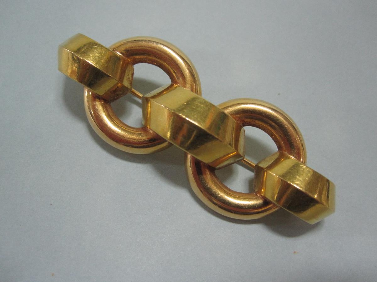 A 19ct gold `chain` link brooch, designed as two chunky ring hoops joined by three angular half