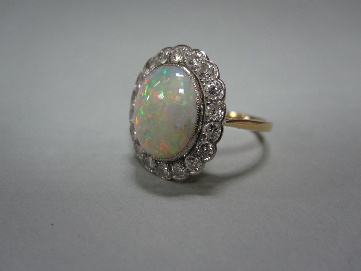 An opal and diamond cluster ring, the oval cabochon opal, exhibiting a fine and rainbow ranged play - Bild 2 aus 4