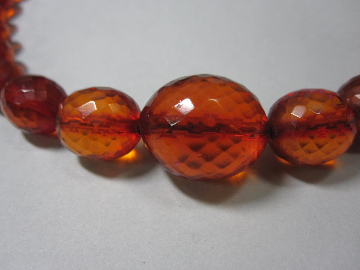 A vintage faceted amber bead necklace, the forty-one graduated oval harlequin faceted beads of - Bild 2 aus 5