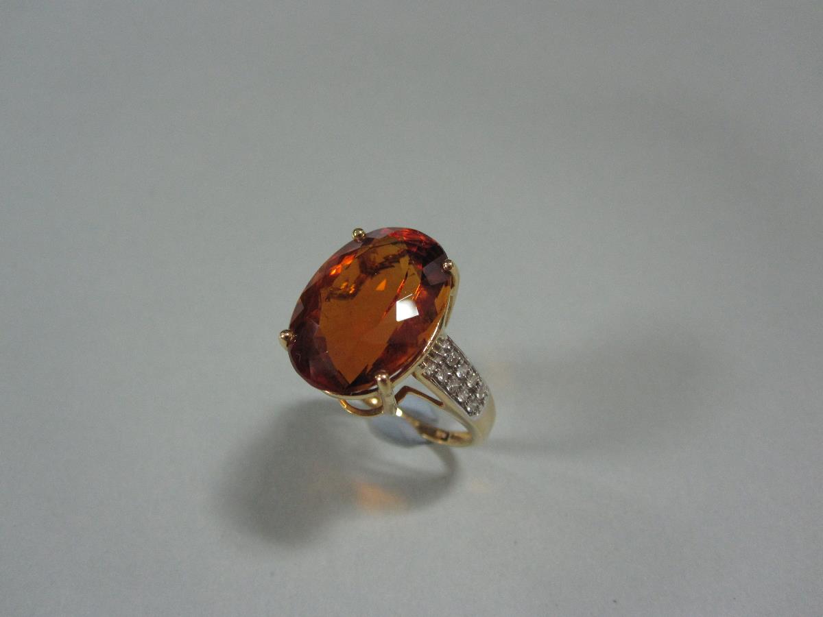 A citrine and diamond ring set in 18ct gold, the oval cut sherry coloured citrine held by four