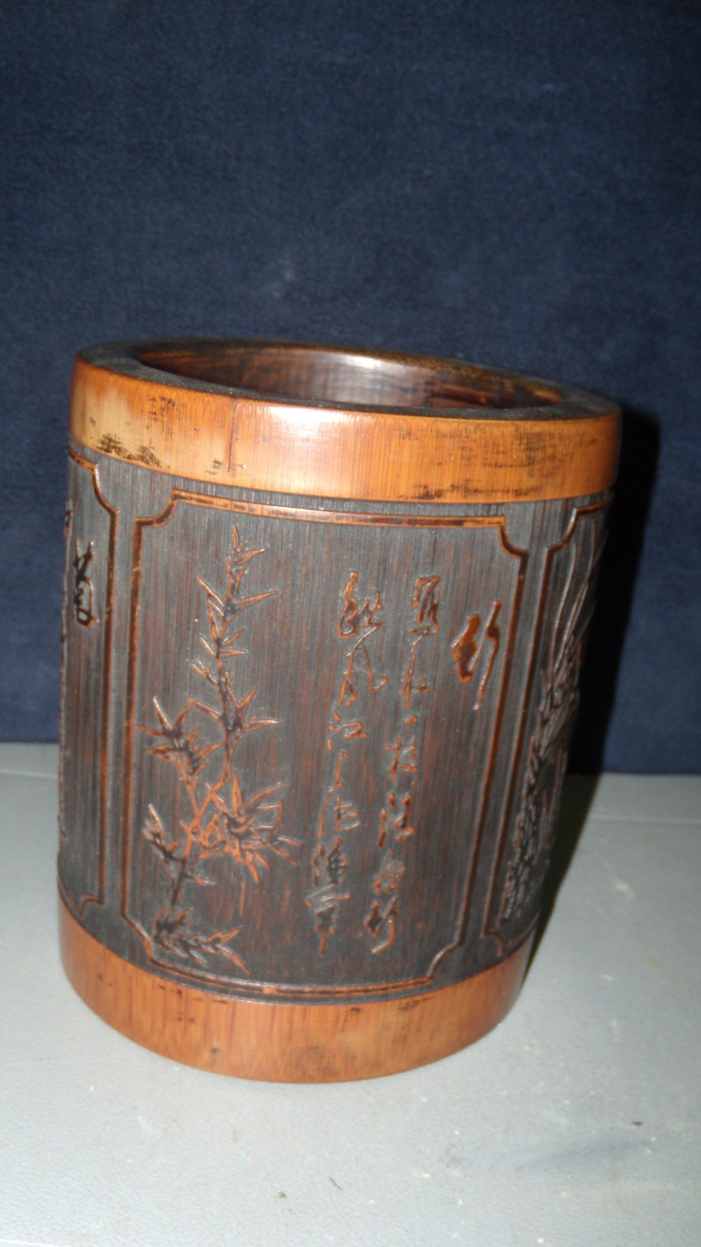 A 19th century bamboo brush pot, the cylindrical sides of the exterior carved with four panels of