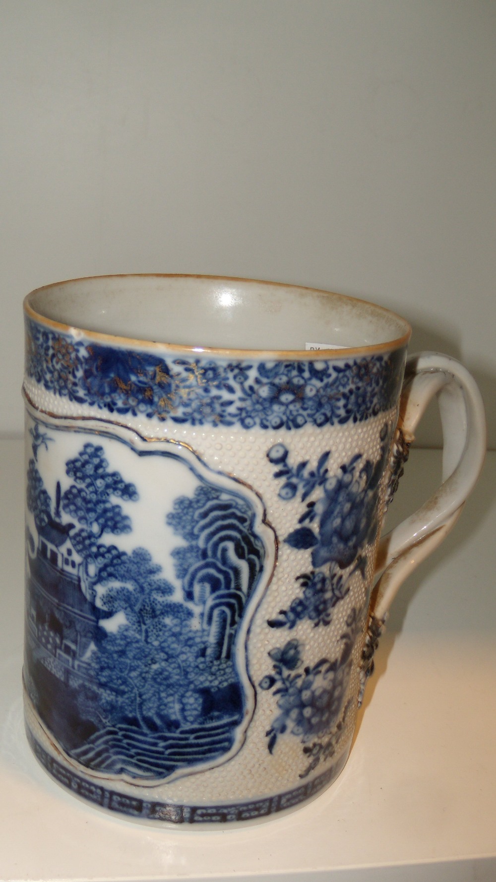 A late 18th/early 19th century blue and white mug, the cylindrical sides of the exterior painted