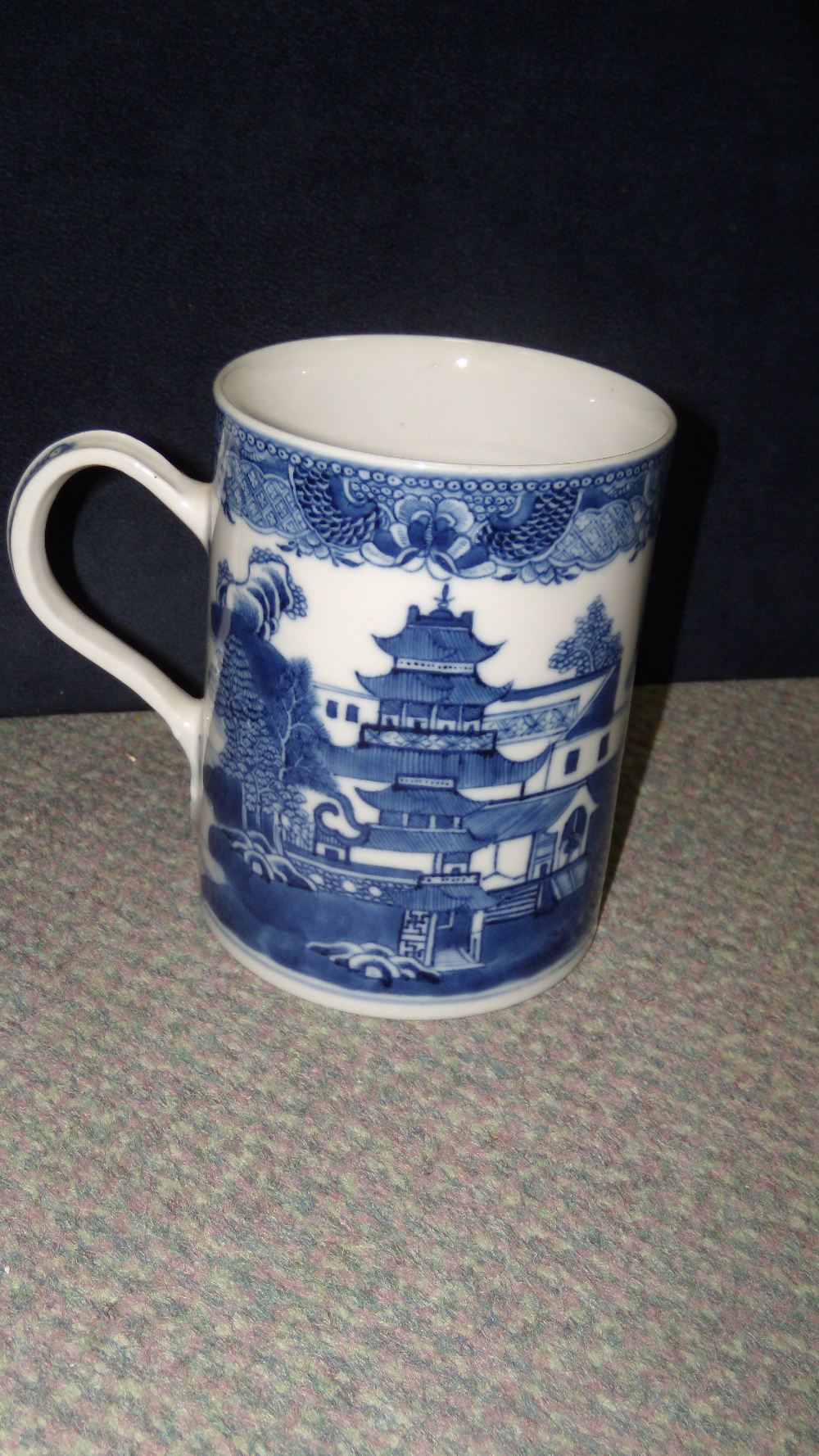 A late 18th/early 19th century blue and white mug, the cylindrical sides of the exterior painted