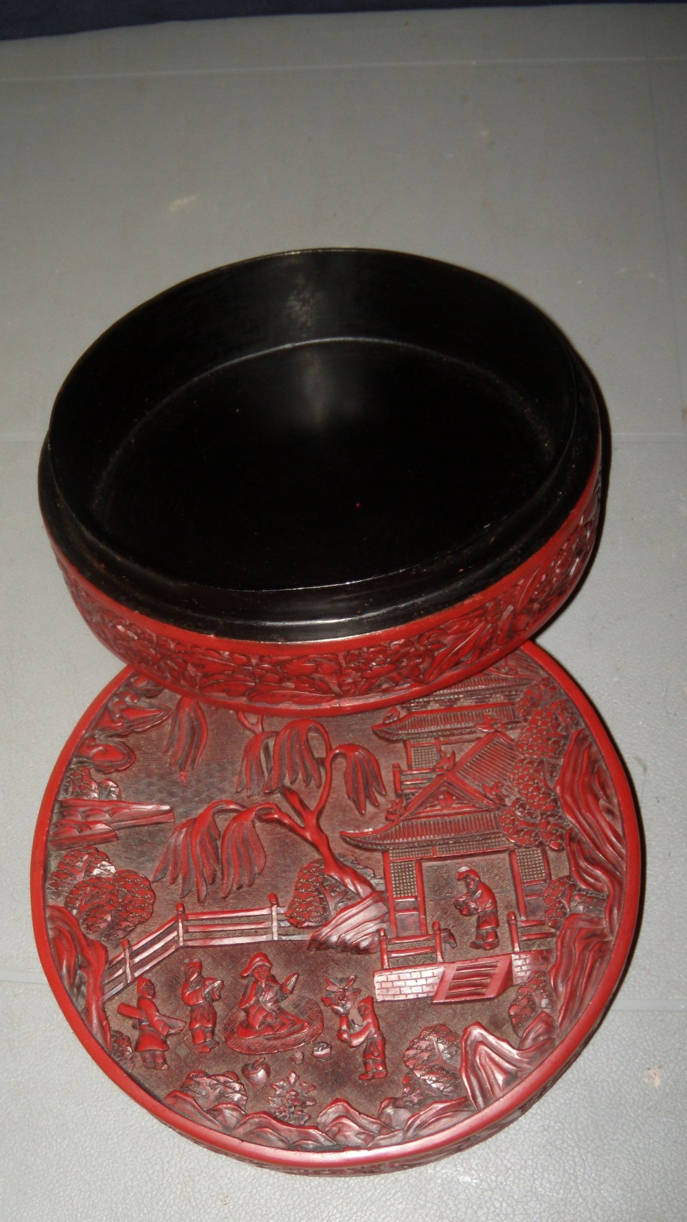 A cinnabar lacquer box and cover, the circular top carved in relief with a dignitary seated on a - Image 2 of 2