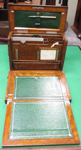 An mid Victorian oak stationery box, the fitted interior with fold out slope