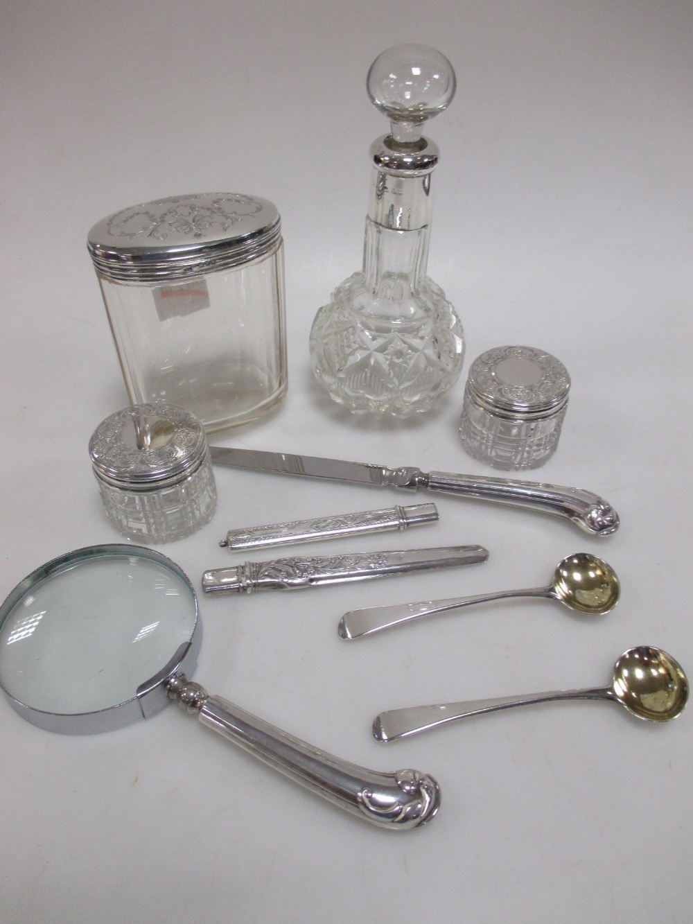 A mixed lot of silver to include: a silver handled magnifying glass, matching paper knife, four