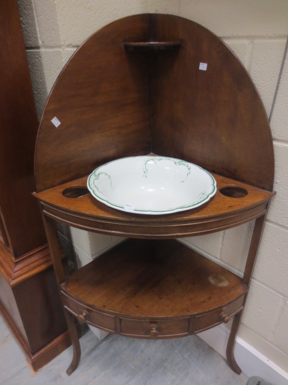 A George III mahogany corner washstand and white and green bowls