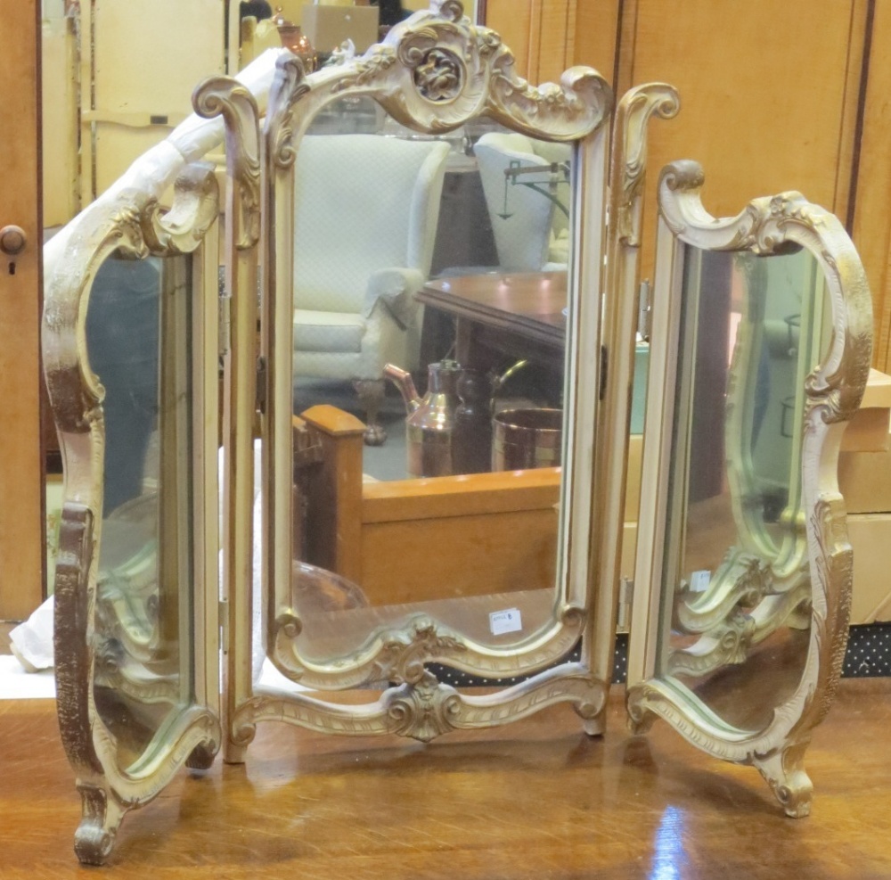 A three fold dressing table mirror with a cream and gilt painted frame, 58cm high